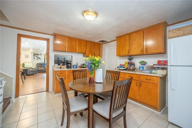 3318 Loam St, Norfolk, VA 23518 - kitchen with freestanding refrigerator, brown cabinets, light countertops, and light tile patterned floors