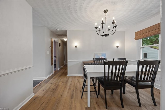 2440 Sir Lance Dr, Chesapeake, VA 23325 - dining area featuring a chandelier, wood finished floors, and a textured ceiling