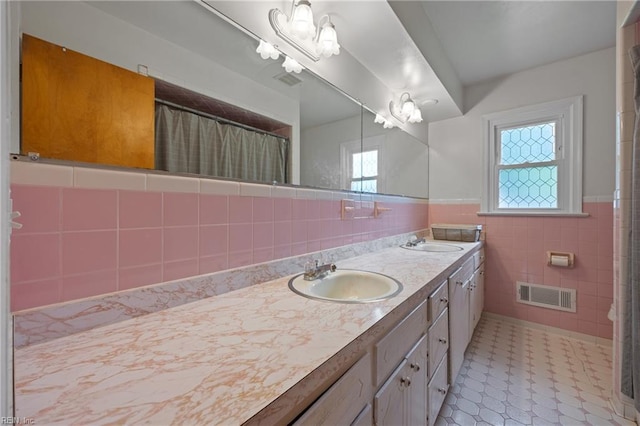 2440 Sir Lance Dr, Chesapeake, VA 23325 - bathroom featuring tile patterned floors, tile walls, double vanity, wainscoting, and a shower with curtain