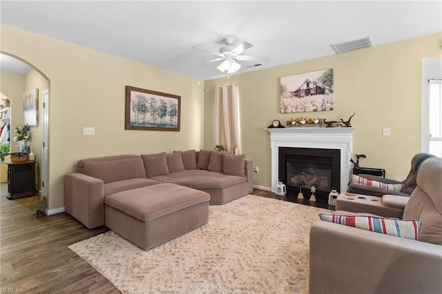 3468 Westham Ln, Toano, VA 23168 - living room featuring a ceiling fan, arched walkways, dark wood-type flooring, and a fireplace with flush hearth