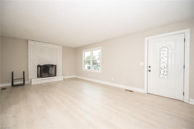 961 Hugo St, Norfolk, VA 23513 - unfurnished living room featuring light wood-style floors and a brick fireplace