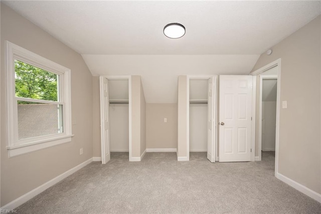 961 Hugo St, Norfolk, VA 23513 - unfurnished bedroom featuring lofted ceiling, two closets, and light colored carpet