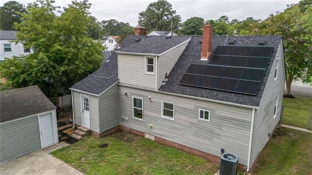 961 Hugo St, Norfolk, VA 23513 - rear view of house featuring roof with shingles, solar panels, a chimney, a storage unit, and crawl space