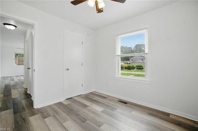4400 Bart St, Portsmouth, VA 23707 - unfurnished bedroom with multiple windows, wood finished floors, and ceiling fan