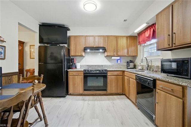 1733 Olde Buckingham Rd, Hampton, VA 23669 - kitchen with black appliances, under cabinet range hood, light stone counters, and light wood-style flooring