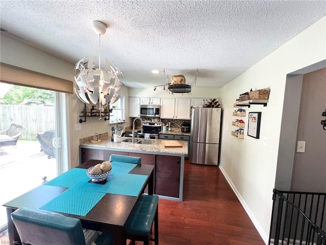 5806 Edith Ct, Virginia Beach, VA 23464 - kitchen with appliances with stainless steel finishes, a chandelier, a peninsula, white cabinets, and a textured ceiling