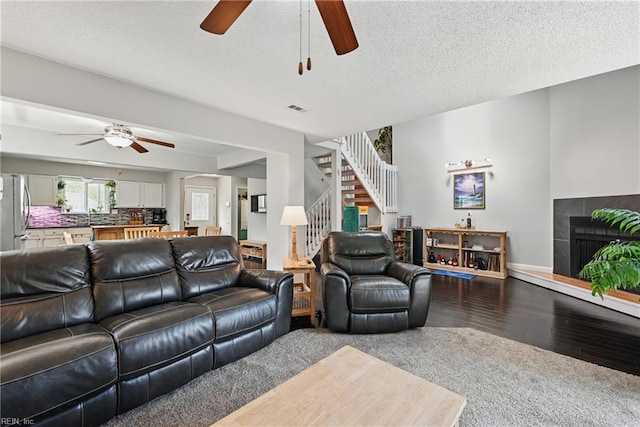 1712 Willwood Ct, Virginia Beach, VA 23464 - living area featuring ceiling fan, stairs, a tile fireplace, wood finished floors, and a textured ceiling