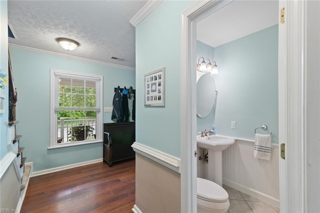 301 Ashland Ct, Newport News, VA 23606 - half bathroom with a textured ceiling, crown molding, wood finished floors, and a wainscoted wall