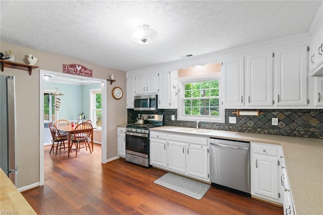 301 Ashland Ct, Newport News, VA 23606 - kitchen featuring stainless steel appliances, dark wood finished floors, backsplash, white cabinets, and a textured ceiling