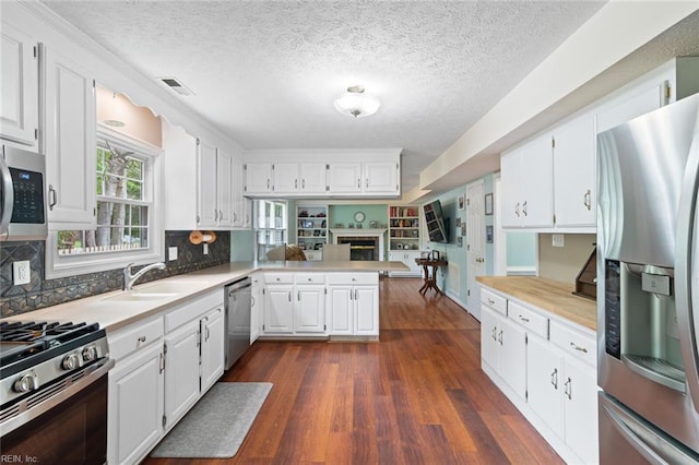 301 Ashland Ct, Newport News, VA 23606 - kitchen with stainless steel appliances, a peninsula, light countertops, and a textured ceiling