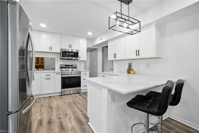 608 Woodbine Ln, Virginia Beach, VA 23452 - kitchen with appliances with stainless steel finishes, a peninsula, light wood-style flooring, white cabinets, and recessed lighting
