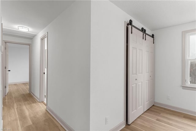 2370 Pruden Blvd, Suffolk, VA 23434 - hallway with a barn door, light wood-type flooring, and a textured ceiling