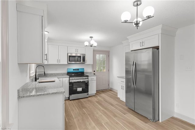 2370 Pruden Blvd, Suffolk, VA 23434 - kitchen with appliances with stainless steel finishes, a chandelier, white cabinetry, light wood finished floors, and light stone counters