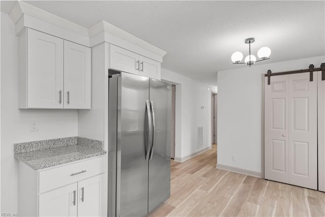 2370 Pruden Blvd, Suffolk, VA 23434 - kitchen featuring freestanding refrigerator, a barn door, white cabinetry, and light wood finished floors
