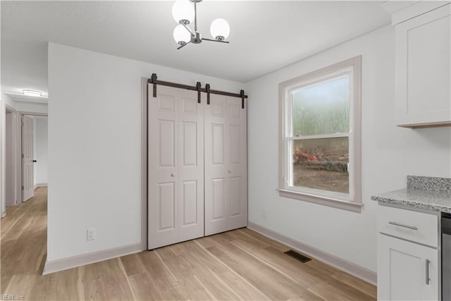 2370 Pruden Blvd, Suffolk, VA 23434 - unfurnished dining area with light wood-style flooring, a barn door, and a chandelier