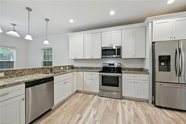 3005 Overbrook Ave, Norfolk, VA 23513 - kitchen featuring stainless steel appliances, light wood-style flooring, white cabinets, light stone countertops, and pendant lighting