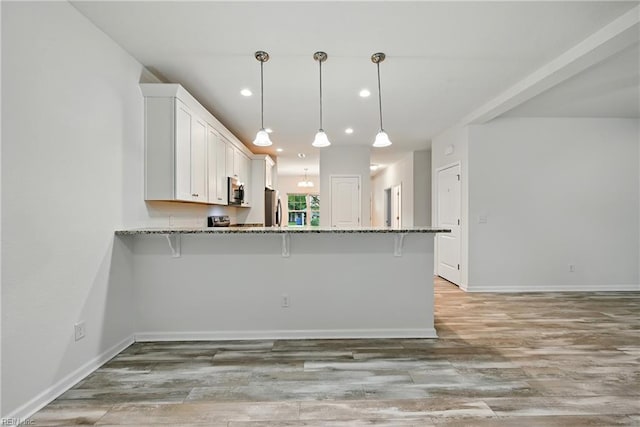 3005 Overbrook Ave, Norfolk, VA 23513 - kitchen featuring stainless steel appliances, light stone counters, a breakfast bar area, white cabinets, and recessed lighting