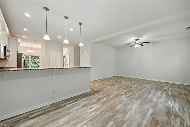 3005 Overbrook Ave, Norfolk, VA 23513 - kitchen featuring freestanding refrigerator, a breakfast bar, light stone counters, light wood-style flooring, and recessed lighting