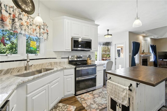 609 Trumpet Ct, Chesapeake, VA 23323 - kitchen featuring appliances with stainless steel finishes, white cabinets, decorative backsplash, decorative light fixtures, and dark stone countertops