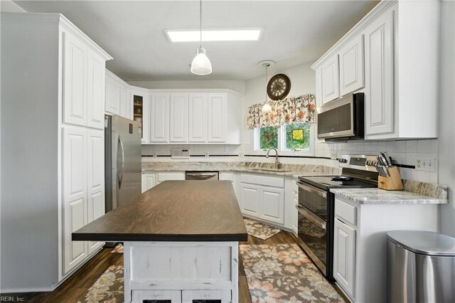 609 Trumpet Ct, Chesapeake, VA 23323 - kitchen featuring stainless steel appliances, white cabinetry, decorative backsplash, a center island, and hanging light fixtures