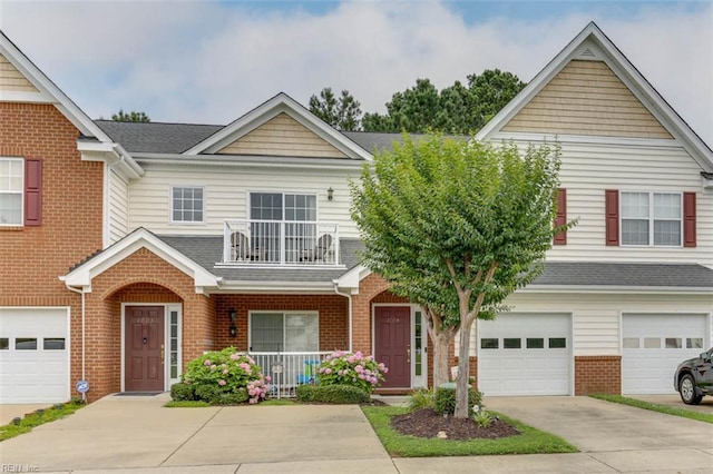1004 Rustads Cir, Williamsburg, VA 23188 - view of front facade featuring a balcony, driveway, brick siding, covered porch, and an attached garage