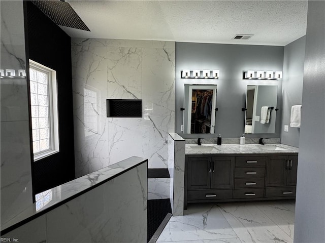 1305 Simms Arch, Chesapeake, VA 23322 - bathroom featuring a marble finish shower, marble finish floors, double vanity, and a textured ceiling