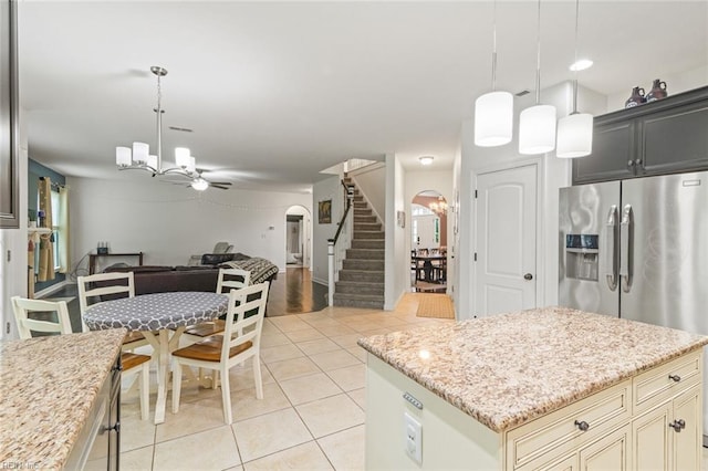308 Queen Ct, Smithfield, VA 23430 - kitchen featuring a chandelier, arched walkways, light tile patterned floors, open floor plan, and light stone counters