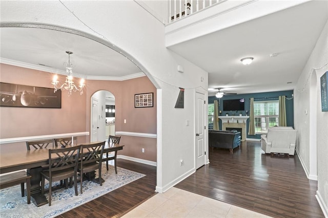 308 Queen Ct, Smithfield, VA 23430 - dining space featuring arched walkways, a ceiling fan, wood finished floors, a chandelier, and a fireplace