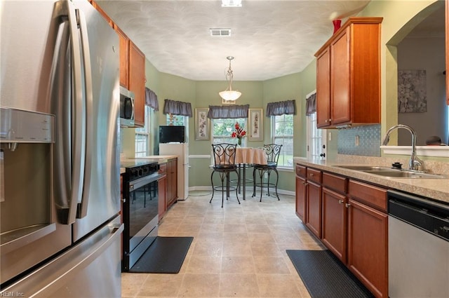 2559 Golden Maple Dr, Suffolk, VA 23434 - kitchen featuring appliances with stainless steel finishes, light countertops, arched walkways, and brown cabinets