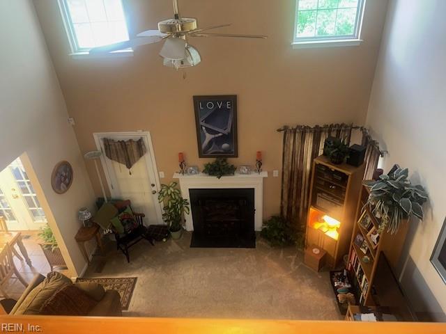 203 Lentz Pl, Newport News, VA 23602 - carpeted living room featuring a towering ceiling, healthy amount of natural light, a fireplace with flush hearth, and ceiling fan