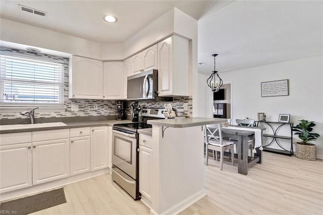 1256 Etworth Ln, Virginia Beach, VA 23464 - kitchen with appliances with stainless steel finishes, backsplash, white cabinetry, light wood-style floors, and recessed lighting