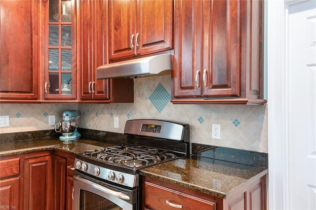 3033 N James Dr, Suffolk, VA 23435 - kitchen featuring stainless steel gas range, under cabinet range hood, glass insert cabinets, backsplash, and dark stone counters