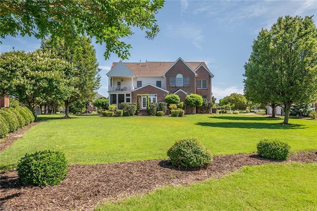 3033 N James Dr, Suffolk, VA 23435 - traditional-style home featuring a front lawn, brick siding, and a balcony
