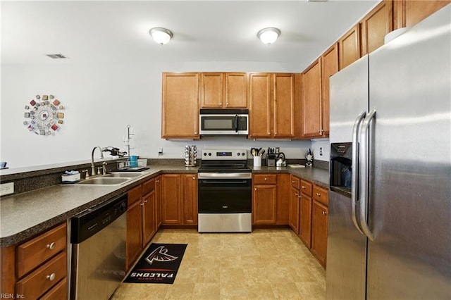 924 Southmoor Dr Unit 204, Virginia Beach, VA 23455 - kitchen with stainless steel appliances, dark countertops, brown cabinetry, and a peninsula