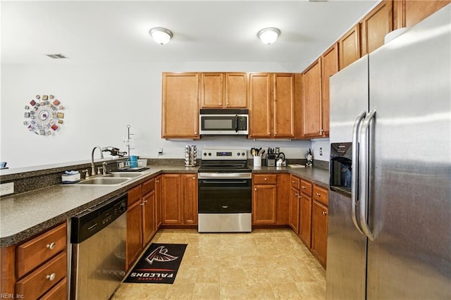 924 Southmoor Dr Unit 204, Virginia Beach, VA 23455 - kitchen featuring appliances with stainless steel finishes, dark countertops, a peninsula, and brown cabinetry