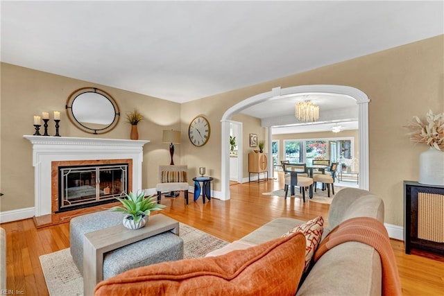 241 Sir Oliver Rd, Norfolk, VA 23505 - living room with arched walkways, wood finished floors, a chandelier, and a glass covered fireplace