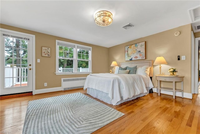 241 Sir Oliver Rd, Norfolk, VA 23505 - bedroom with radiator heating unit, access to exterior, and light wood-style flooring