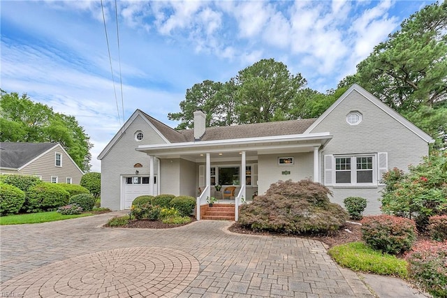241 Sir Oliver Rd, Norfolk, VA 23505 - view of front of property with brick siding, covered porch, a chimney, curved driveway, and a garage