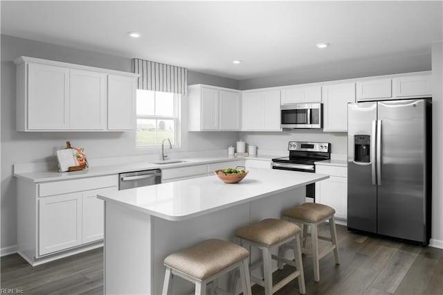 3617 Clyde St, Elizabeth City, NC 27909 - kitchen featuring appliances with stainless steel finishes, a breakfast bar area, white cabinets, a kitchen island, and dark wood-style floors