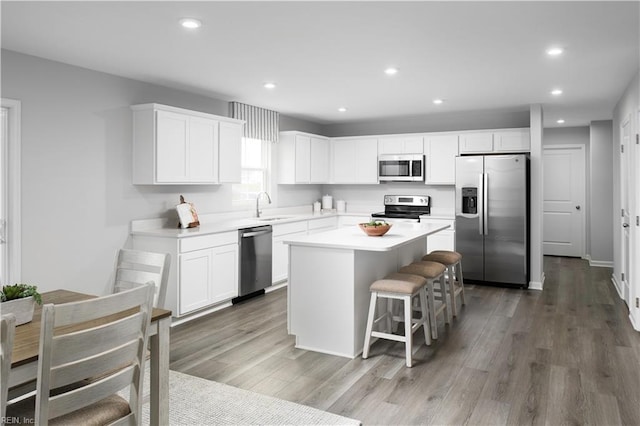 3617 Clyde St, Elizabeth City, NC 27909 - kitchen featuring appliances with stainless steel finishes, a center island, white cabinets, recessed lighting, and a breakfast bar