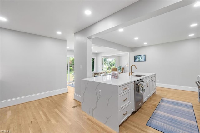 6070 Newport Pt, Norfolk, VA 23505 - kitchen featuring stainless steel dishwasher, light wood-style flooring, light stone countertops, an island with sink, and white cabinets
