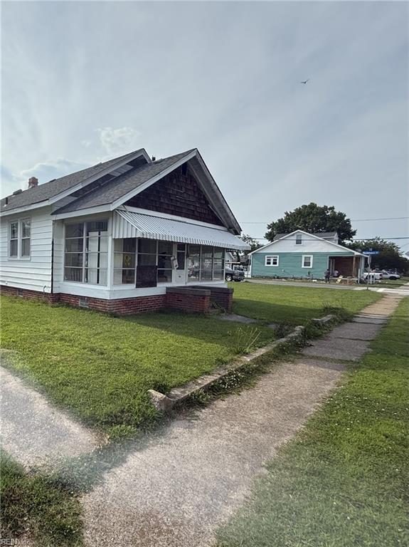 261 N First St, Hampton, VA 23664 - view of side of property with a lawn, a sunroom, and a shingled roof