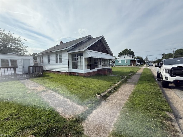 261 N First St, Hampton, VA 23664 - view of side of home featuring roof with shingles, a lawn, and a sunroom
