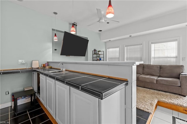 2320 Early St, Norfolk, VA 23513 - kitchen with dark tile patterned floors, open floor plan, a peninsula, a ceiling fan, and white cabinets