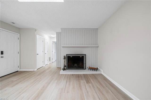 146 Saw Grass Bnd, Virginia Beach, VA 23451 - unfurnished living room featuring wood finished floors, a brick fireplace, and a textured ceiling