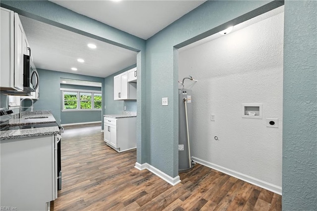 2214 Berkley Ave, Chesapeake, VA 23324 - kitchen with a textured wall, dark wood finished floors, stainless steel microwave, water heater, and light stone counters
