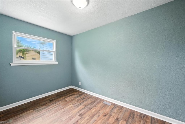 2214 Berkley Ave, Chesapeake, VA 23324 - spare room with wood finished floors, a textured ceiling, and a textured wall