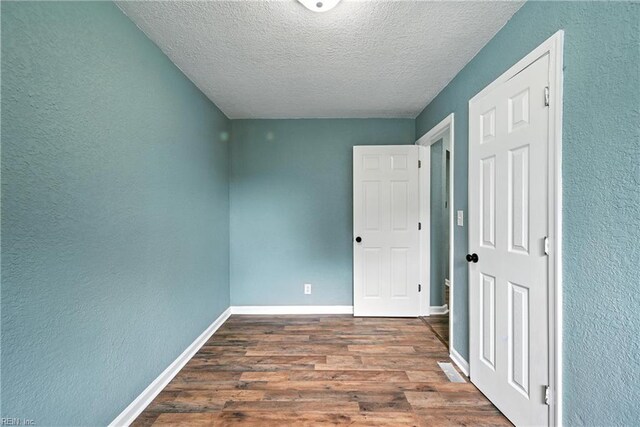 2214 Berkley Ave, Chesapeake, VA 23324 - unfurnished bedroom featuring wood finished floors, a textured ceiling, and a textured wall