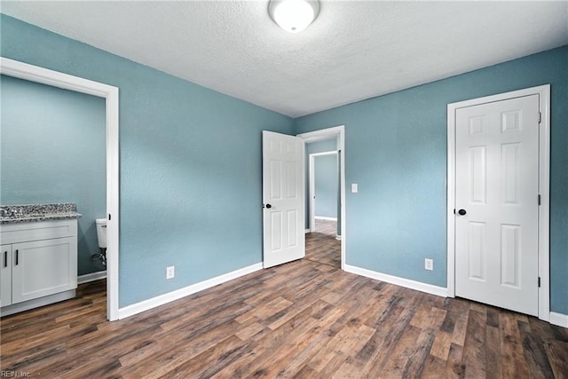 2214 Berkley Ave, Chesapeake, VA 23324 - unfurnished bedroom featuring dark wood-style flooring, a textured ceiling, and connected bathroom