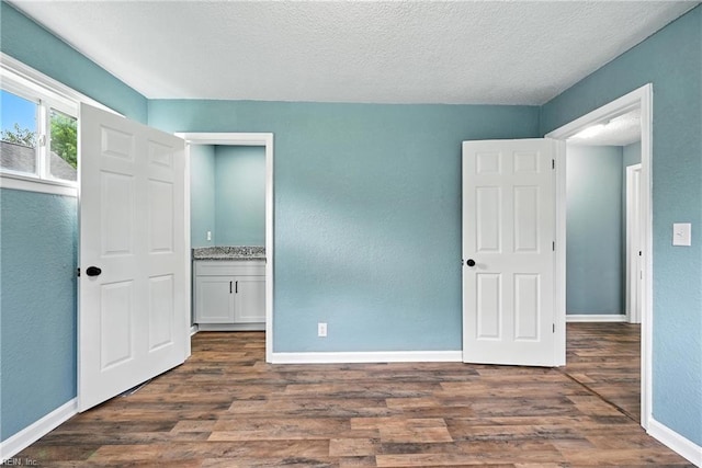 2214 Berkley Ave, Chesapeake, VA 23324 - unfurnished bedroom with dark wood-style floors, a textured ceiling, and a textured wall
